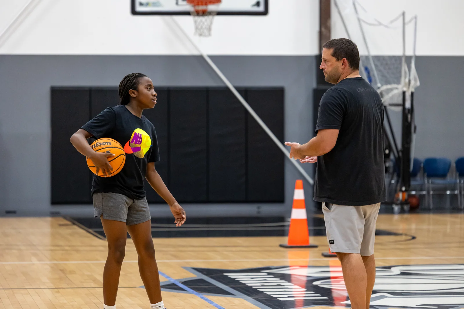 Academy athlete receiving feedback from a coach on her shot during an Academy session at Training Zone in Herriman, Utah