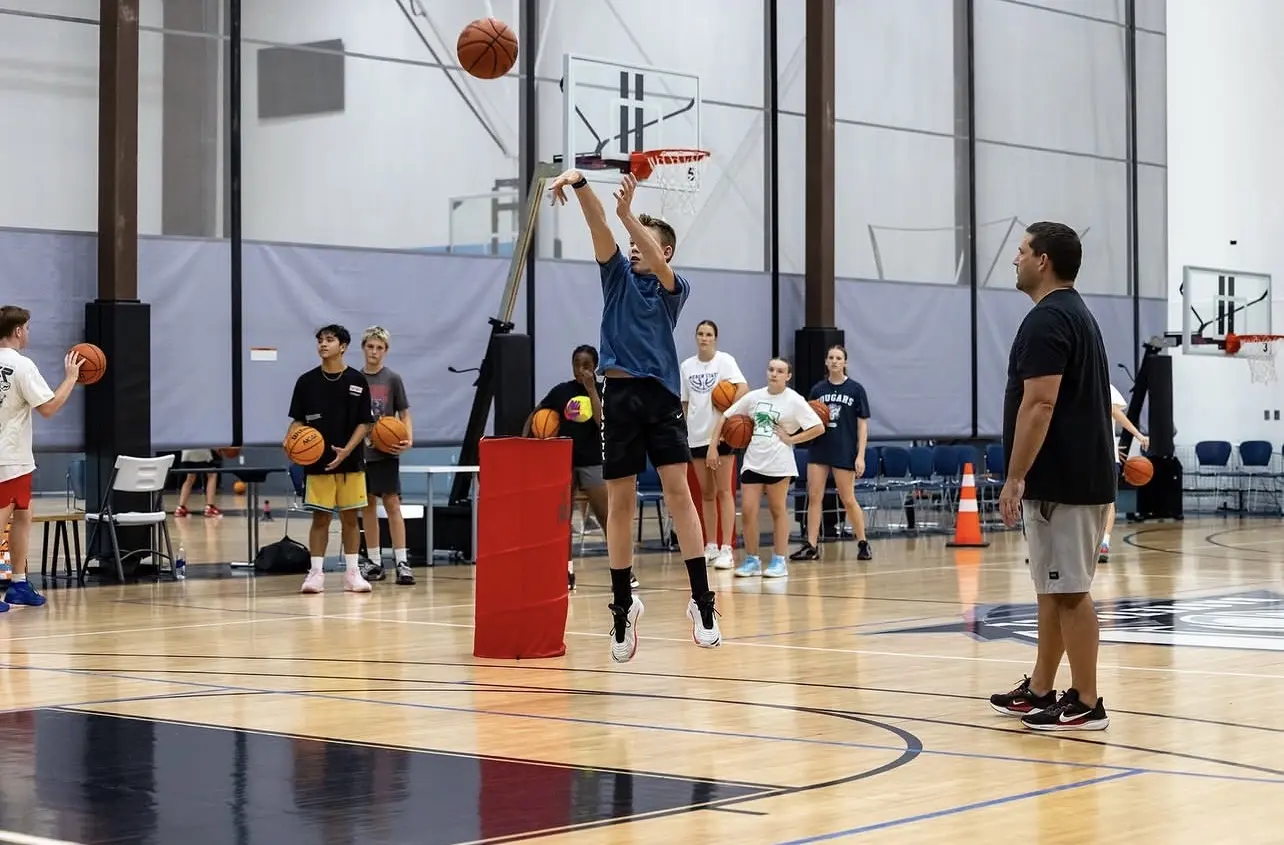 Shot Camp at Training Zone — an athlete rises into a jumper while Coach Matt watches
